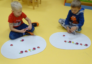 13 chłopcy układają rytmy z kartoników z owocami